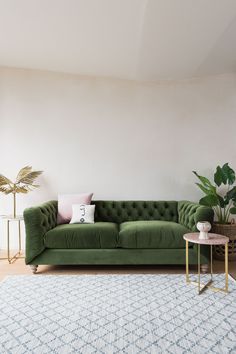 a green couch in front of a white wall