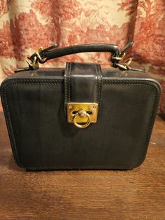 A Perfect Square OR close to it (8x6)! Adorable Black Leather w/Gold Trim transitional bag from the 1980s...Square shaped with a top handle and a removable shoulder strap. Flap over closure, footed bottom, and middle zipper pocket.  Compact and stylish in a vintage bag! Vintage Fringe, Perfect Squares, Carpet Bag, Vintage Bag, Shoulder Bag Black, Vintage Scarf, Beautiful Hats, Vintage Bags, Vintage Leather