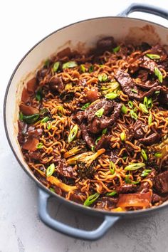 beef and noodles with broccoli in a skillet on a white counter top