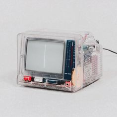 an old fashioned computer sitting on top of a white table next to wires and other electronics