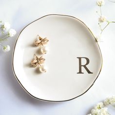 two pearls are placed on a plate with the letter r in front of them and white flowers