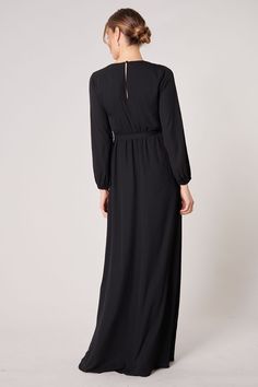 Warm and inviting, the Wholehearted Maxi Dress is a perfect combination of modest and sultry. Long balloon sleeves frame a surplice neckline separated by a tie at the waist, creating a forgiving faux wrap. The skirt maintains an airy and flowy shape that trails behind as you walk down the aisle. - Chiffon- Faux wrap- Keyhole- Elastic waist- Comes in 14 ColorsSize + Fit - Model is 5'9" and wearing size XS- Measurements taken from size S - Chest: 35"- Length: 63 1/4" Fabric Self: 100% PolyesterLin Modest V-neck Formal Dress, Modest Fitted V-neck Maxi Dress, Fitted Maxi Length V-neck Wedding Dress, Modest Solid Color Maxi Dress For Evening, Modest V-neck Maxi Dress For Party, Modest Floor-length Maxi Dress For Formal Occasions, Modest V-neck Party Dress, Fitted Maxi Dress With Surplice Neckline For Formal Occasions, Modest V-neck Dress For Formal Occasions