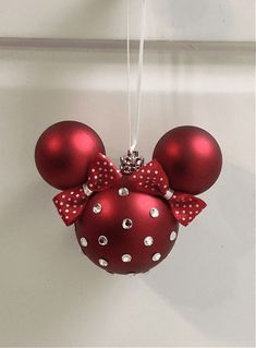 a minnie mouse ornament hanging on a wall with a red polka dot bow