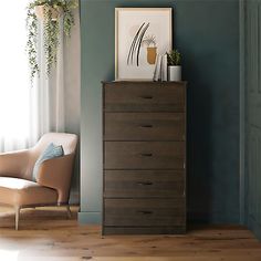 an empty chair sits next to a dresser in a room with blue walls and wooden floors