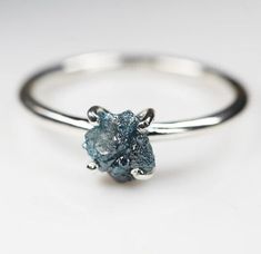 a silver ring with a blue stone on it