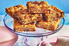 a glass plate filled with granola bars on top of a table next to a blue wall