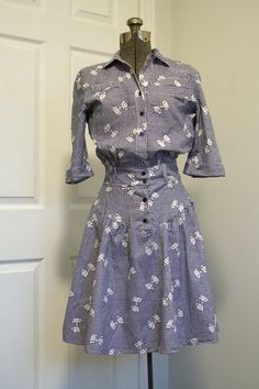 "This super adorable dress is a charming 1930s- or 40s-esque retro look from the early 1970s with some really interesting style elements. -material is 100% cotton -print is an adorable blue and white gingham check pattern, scattered with bows which are dotted with tiny hearts. -shirtwaist style with collar and elbow-length sleeves with turn-up cuffs -loose-fitting blouson bodice with fitted waist and hips -false chest pockets -straight waistband with v-shaped basque waistline extension below it, Retro Gingham Cotton Vintage Dress, Retro Gingham Vintage Dress In Cotton, Retro Gingham Vintage Cotton Dress, Blue 1950s Style Cotton Vintage Dress, 1950s Gingham Cotton Dresses, 1950s Style Blue Cotton Vintage Dress, Vintage Gingham Cotton Dress, Fitted Gingham Vintage Cotton Dress, Fitted Cotton Gingham Vintage Dress