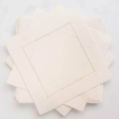 six white napkins stacked on top of each other with stitching at the edges