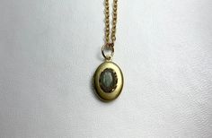 This sweet, small, OVAL antique brass locket has a Labradorite cabochon set on the front.  The cabochon sits in a brass lace edged setting. It hangs on a 16" gold-plated stainless-steel chain necklace.  The locket is approximately 11x16mm.  The cabochon is 5x7mm.  Arrives in an eco-friendly jewelry box, ready for gifting. MORE lockets in my shop! FREE SHIPPING! THANK YOU FOR VISITING MY SHOP! Oval Cabochon Brass Necklace, Handmade Oval Brass Locket Necklace, Antique Gold Cabochon Brass Necklace, Antique Gold Brass Necklace With Cabochon, Handmade Gold Locket Necklace For Memorial, Stainless Steel Chain Necklace, Eco Friendly Jewelry, Labradorite Cabochon, Lace Edging