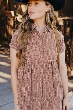 Introducing The Zuri Dress, a playful knee-length western dress in a gorgeous rust color. Made from textured fabric, this dress features a flattering fit and flare silhouette with short sleeves and a v neckline. Complete with a collared button down design and pocket detail, it's the perfect dress for fall fun! Haylee is wearing size small paired with the Ariat Casanova Boots, Felt Cowboy ProHat and The Talia Bag