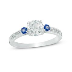 A beautiful choice, this vintage-inspired ring is certain to be adored the instant it's presented to her. Crafted in sterling silver, this striking three-stone look features a shimmering 6.25mm lab-created white sapphire center stone flanked on each side by a smaller lab-created bright blue sapphire. Created white sapphires glisten in a neat row on either side of the shank, while intricate milgrain details add even more interest to this heirloom-styled piece. Simply timeless, this design is buff Classic White Sapphire Ring With Accent Stones, Classic Three Stone Birthstone Ring, Classic Three Stone Jewelry With Lab-created Sapphire, Classic White Birthstone Ring With Accent Stones, Classic Sapphire Ring With Side Stones For Anniversary, Zales Engagement Rings, Vintage Style Rings, Three Stone Ring, Dream Engagement Rings