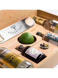 an assortment of alcohol and condiments in a wooden box