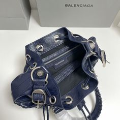 Balenciaga &apos;s popular "Le Cagole" series is a modern interpretation of its "City" handbags - reshaped into a bucket bag design to inject a new soul into it. The large size adds two round top handles, combining classic and Modern trends are perfectly integrated. On the basis of retaining the original DNA of the motorcycle bag&apos;s flat rivets, delicate buckles and tassel zippers, it adds adjustable woven shoulder straps and a cute and playful heart-shaped mirror, which New Soul, Shaped Mirror, Motorcycle Bag, Lv Purse, Lv Shoes, Gucci Bamboo, Lv Belt, Lv Handbags, Lv Wallet