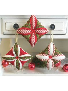 an ornament is hanging on the wall next to a white door with red and green decorations