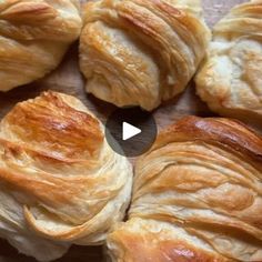 several croissants on a cutting board with one being sliced into small pieces