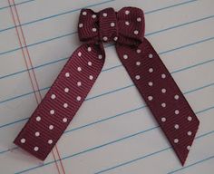 a red and white polka dot bow on lined paper