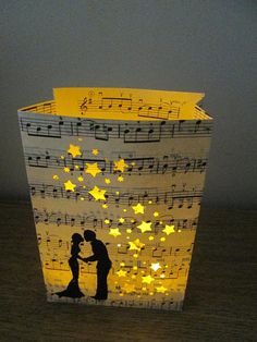 a paper cup with music notes on it and a couple kissing in front of them