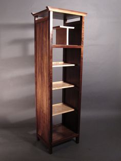 a tall wooden book shelf with shelves on each side