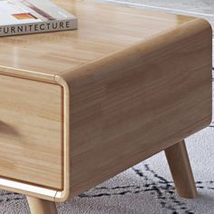 a wooden table with a book on top of it and a rug in the background