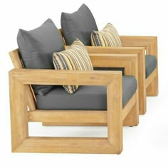 three wooden chairs with pillows on them sitting side by side in front of each other