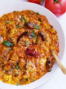 a white bowl filled with food next to tomatoes