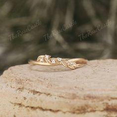 a gold ring with three diamonds on top of a rock