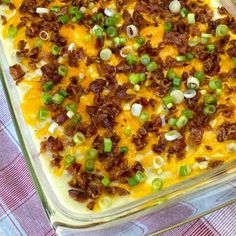 a casserole dish with meat, cheese and green onions