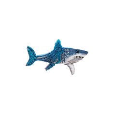 a blue and white beaded shark ornament on a white background with room for text