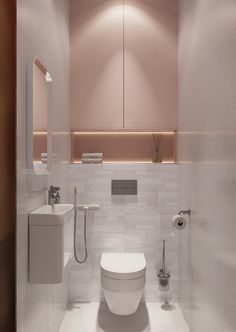 a white toilet sitting in a bathroom next to a sink under a mirror and towel dispenser