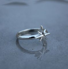 Introducing our stunning silver ring adorned with a captivating star design, perfect for those who seek celestial elegance. This North Star Ring, also known as the Starburst Ring or Pole Star Ring, showcases a dainty star that adds a touch of celestial charm to any outfit. Crafted with meticulous attention to detail, this astrology-inspired piece is a must-have for those who appreciate the beauty of the night sky. Made from high-quality silver, this nautical star ring is a timeless accessory that will effortlessly elevate your style. PRODUCT DETAILS - Material - Silver Ring Size - All Ring Size Available DELIVERY SERVICES- USPS for US Buyers 8-12 Working Days EVRI  for  UK  Buyers 8-12 Working Days IndiaPost International for Other Countries  10-15 working days Dispatched Within 1-3 workin Silver Star-shaped Celestial Midi Rings, Celestial Silver Star Midi Rings, Celestial Sterling Silver Star Ring, Celestial Star-shaped Midi Rings As Gift, Sterling Silver Star-shaped Rings, Sterling Silver Star Midi Ring, North Star Ring, Sparkly Rings, Celestial Style