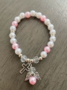 This is a white pearl silver and pink  cross and angel bead bracelet as shown in the picture.    This is a stretch bracelet linked by a elastic string. Ready to ship  Bracelet size is 7 Size adjustable, suits most wrist size range from 6 - 7 inch. It's handmade item make with love and passion. The bracelet is great for Birthday Gifts, Anniversary Gifts, Christmas Gifts, Graduation Gifts, Valentine's Day Gifts for your dear mother, wife, girlfriend or best friend. Gifts To Give Your Girlfriend, Pink And White Bracelet, Angel Bracelet, Pink Cross, White Bracelet, Gifts Anniversary, Great Gifts For Men, White Bracelets, Gifts Christmas