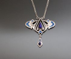 Jugendstil DEPOSE 900 Silver, Lapis Lazuli, Enamel Pendant Necklace. Antique Art Nouveau Jewelry Jugendstil 900 silver necklace. 1900 - 1910's, Pforzheim, Germany. No maker's mark. Clasp in non-precious metal. Tested and hallmarked in Czech Assay Office (2024). Very good antique condition.  With no dents or loses.  Stones intact. Enamel intact. Barrel clasp closure (brass) works fine. Pendant:   1 5/8" 1 3/4"    (41 x 45mm).  Chain from end to end: 17 3/4"   (45cm). Weight:  9,85g. * * * All our Art Deco Sterling Silver Engraved Necklace, Engraved Sterling Silver Art Deco Necklace, Silver Art Deco Medallion Necklace, Art Nouveau Silver Jewelry With 17 Jewels, Collectible Blue Inlay Necklace, Art Deco Hallmarked Sterling Silver Necklaces, Art Deco Sterling Silver Pendant Necklace, Art Nouveau Sterling Silver Jewelry For Formal Occasions, Art Nouveau Sterling Silver Pendant