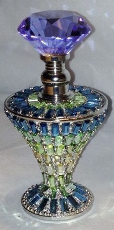 a blue and green glass vase with a diamond on top