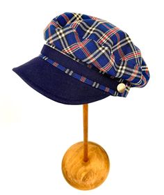 Classic and elegant blue tartan plaid sailor cap. Adorned with a ribbon of the same fabric as the visor and riveted with metallic buttons in old silver color. 65 % polyester 35% linen. Cut and sewn on the bias with a quality tartan plaid fabric and finished with a very light cotton lining. The length of the visor is 4.5 centimeters. The back of the cap has a small eco-leather belt to adjust the measurement up to three centimeters less. It adapts very well to the head. For its production we use t Navy Cotton Brimmed Hat, Adjustable Sailor Style Cap, Adjustable Sailor Cap, Blue Casual Mini Hat With Adjustable Fit, Adjustable Navy Wide Brim Hat, Casual Blue Mini Hat With Adjustable Fit, Casual Blue Adjustable Mini Hat, Navy Cotton Hat With Short Brim, Casual Blue Cloche Hat With Short Brim