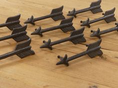 several metal arrows are arranged on a wooden surface