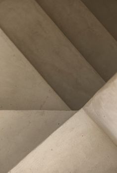 a skateboarder is going down the stairs in an indoor area with concrete walls