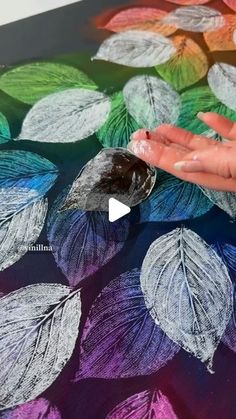 someone is painting leaves on a table cloth