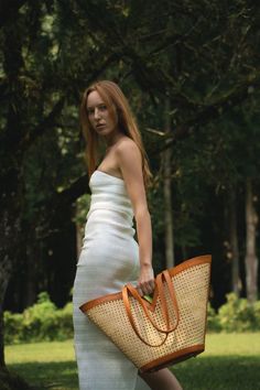 Introducing our NEW Cabo Beach Tote in tan, perfect for a day in the sun or a weekend getaway. Made from natural cane and premium leather, this spacious and stylish tote comes with an interior hanging wallet for added organization and security. Crafted with care by our artisan partners in Bali, Indonesia, our beach tote is both sustainable and ethical. Shop now and enjoy free shipping on all orders. Tote Bag Photoshoot, Cabo Beach, Bag Photoshoot, Leather Basket, Wicker Bags, Leather Artisan, Straw Bags, Us Beaches, Resort Collection