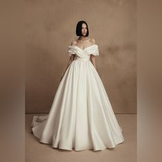 a woman in a white wedding dress posing for the camera with her hands on her hips