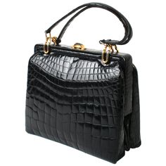 Black alligator handbag with matching double straps and gold-tone link hardware. It has double accordion construction, a two-tone push-button closure and a wide hinged opening. The purse is lined in a soft tan suede with two alligator lined side pockets and an accordion zipper pocket. No labels. Measures 16.5"H to top of straps x 11"W x 5"D. N. P. Trent Antiques has been a respected name in antiques for over 30 years with a large collection of period furniture, art, books, jewelry and decorative Bag Logo Design, Alligator Purse, Alligator Handbags, Bag Logo, Black Alligator, Ladies Bag, Kelly Bag, Trendy Handbags, Gold Handbags