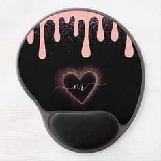 a black and pink mouse pad with a heart in the middle, dripping paint on it