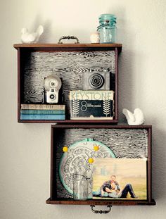 two wooden shelves with pictures and other items on them