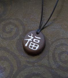 Japanese kanji ''Good Fortune'' necklace. For men and for women, unisex pendant.  The ceramic pendant is handmade from black clay. Unglazed black clay has a very natural, stone like feeling. But unlike stone, ceramic pendant is very light weight. It will be sent to you in a matte black gift box, suitable for men and women. It is a perfect gift for your loved ones ready to present. Free delivery with $35 purchase. All orders are shipped by registered mail.  You will receive a tracking number afte Chinese Pendant, Japanese Jewelry, Good Luck Necklace, Ceramic Molds, Good Luck Gifts, Japanese Kanji, Black Clay, Protection Necklace, Yoga Gifts