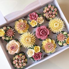 cupcakes decorated with flowers in a box