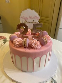 a pink and white birthday cake with the number twenty five on it's top