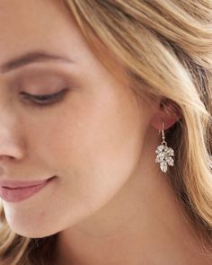 a close up of a woman wearing earrings with flowers on it's earring