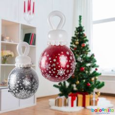 two ornaments hanging from the ceiling in front of a christmas tree