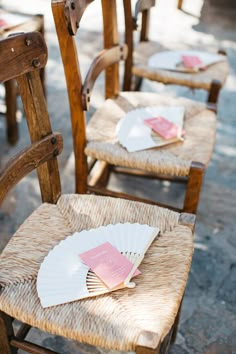 the chairs are lined up with cards and paper on them for guests to sit in