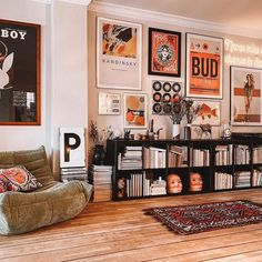 a living room filled with lots of furniture and pictures on the wall next to a book shelf