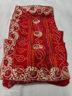 Indian Handmade Cutdana Ans Gardogi With Stone Work Saree, Unique Design Work Saree Item: Handmade Gotta Patti Bandhej Saree Fabric: Georgette Blouse: Handmade Gotta Patti Traditional Red Pre-draped Saree For Festive Occasions, Traditional Semi-stitched Blouse Piece With Gota Work, Festive Pre-draped Saree With Mirror Work For Puja, Festive Red Pre-draped Saree With Zari Work, Bollywood Style Red Choli In Chinon, Red Bandhani Print Pre-draped Saree In Art Silk, Red Chinon Lehenga For Navratri, Traditional Saree With Dori Work For Transitional Season, Festival Semi-stitched Bandhani Print Saree